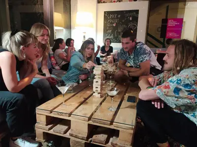 a group of people sitting around a table playing chess at STAY Rhodes HoStel & Bar in Rhodes Town
