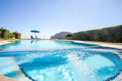 a swimming pool with blue water and an umbrella at Villa Seashell in Pefki Rhodes