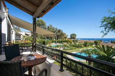 a balcony with a table and chairs and a view of the ocean at Villa Seashell in Pefki Rhodes