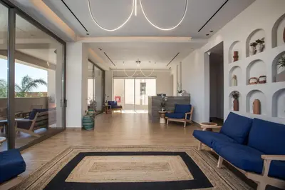 a living room with a blue couch and chairs at Este Elegant Suites & Villas in Kiotari