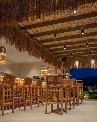 a group of chairs and tables in a restaurant at Este Elegant Suites & Villas in Kiotari