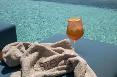 a glass of wine sitting on a towel next to a pool at Este Elegant Suites & Villas in Kiotari