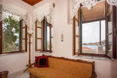 a living room with a couch and windows at Isminis Villa in Halki