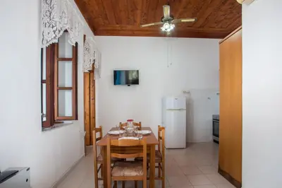 a kitchen with a table and chairs and a refrigerator at Isminis Villa in Halki