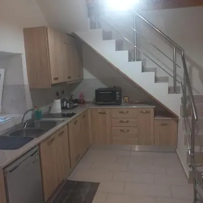 a kitchen with a sink and a staircase at Sunnyside Apartment in Rhodes Town