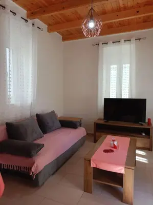 a living room with a couch and a flat screen tv at Sunnyside Apartment in Rhodes Town