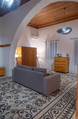 a living room with a couch and a table at Diolanth traditional house in Koskinou