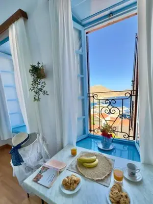 a table with food on it in front of a window at Maestro apartment Chalki in Halki