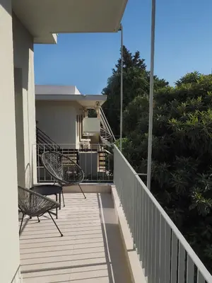 a balcony of a house with two chairs at Trinity Urban Residences Plumeria in Rhodes Town