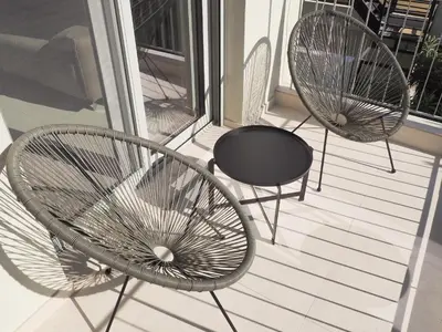 two chairs and a table on a balcony at Trinity Urban Residences Plumeria in Rhodes Town