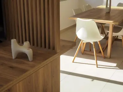 a white chair sitting next to a wooden table at Trinity Urban Residences Plumeria in Rhodes Town