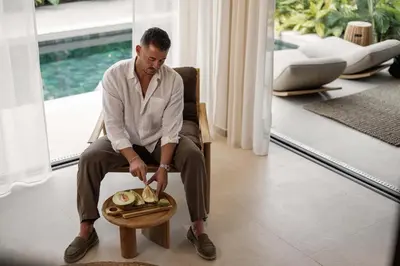 a man sitting in a chair with a plate of food at Terra Mare Villas in Ialyssos
