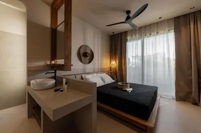 a bedroom with a bed and a sink and a ceiling fan at Terra Mare Villas in Ialyssos