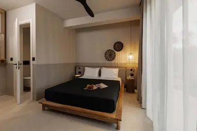 a bedroom with a bed and a clock on the wall at Terra Mare Villas in Ialyssos