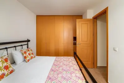 a bedroom with a bed and a wooden closet at Villa Daphne in Kalathos