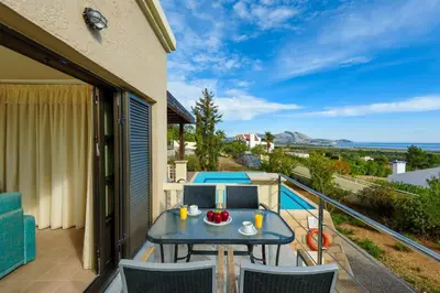 a patio with a table and chairs on a balcony at Villa Daphne in Kalathos
