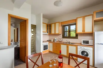 a kitchen with a table with wine glasses on it at Villa Daphne in Kalathos