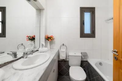 a bathroom with a sink and a toilet and a tub at Villa Daphne in Kalathos