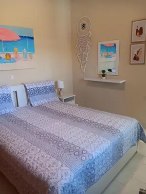 a bedroom with a large bed with a blue comforter at Giulia's Beach House in Rhodes Town
