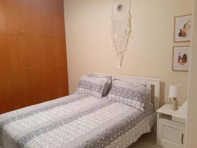 a bedroom with a bed with a white comforter and pillows at Giulia's Beach House in Rhodes Town