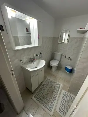 a white bathroom with a sink and a toilet at Giulia's Beach House in Rhodes Town