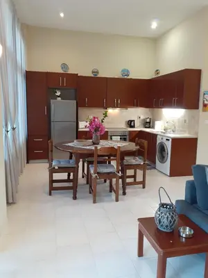 a living room with a table and a kitchen at Giulia's Beach House in Rhodes Town