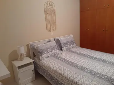 a bedroom with a bed and a dresser and a night stand at Giulia's Beach House in Rhodes Town