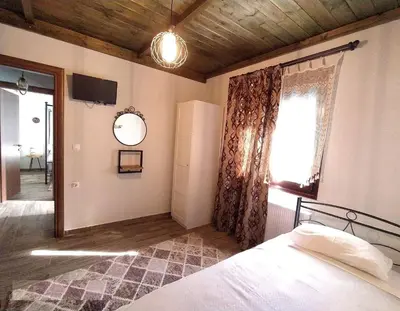 a bedroom with a bed and a window and a mirror at Rustic House Smaro in Émbonas