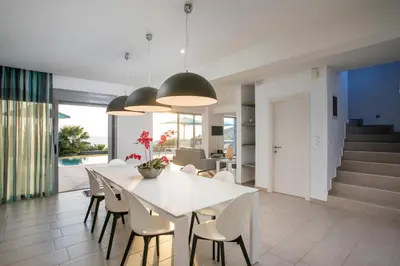 a dining room and living room with a white table and chairs at Villa Lily in Pefki Rhodes