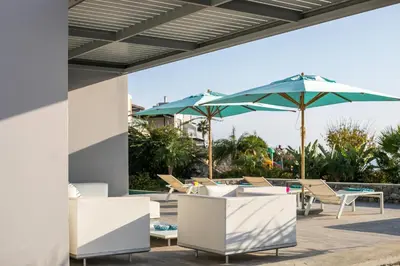 a patio with tables and umbrellas and chairs at Villa Lily in Pefki Rhodes