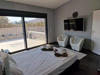 a bedroom with a large bed and a large window at Villa Aurelia Privat Pool in Kolimbia