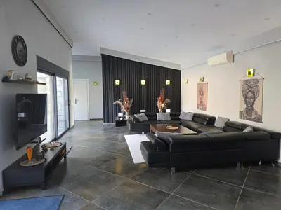 a living room with black couches and a tv at Villa Aurelia Privat Pool in Kolimbia
