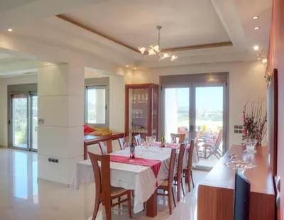 a dining room with a table and some chairs at Villa Artemis in Koskinou