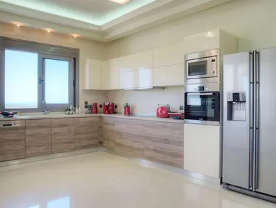 a kitchen with a stainless steel refrigerator and cabinets at Villa Artemis in Koskinou