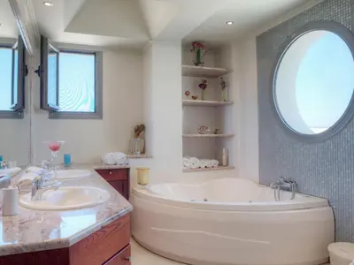 a bathroom with two sinks and a large tub at Villa Artemis in Koskinou