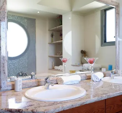 a bathroom with two sinks and a large mirror at Villa Artemis in Koskinou