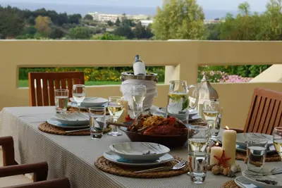 a table with plates of food and wine glasses at Villa Artemis in Koskinou
