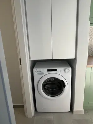 a washing machine with a white cabinet above it at FEDON Guesthouse in Halki