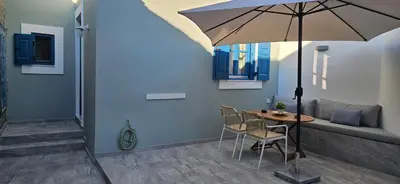 a living room with a table and an umbrella at FEDON Guesthouse in Halki
