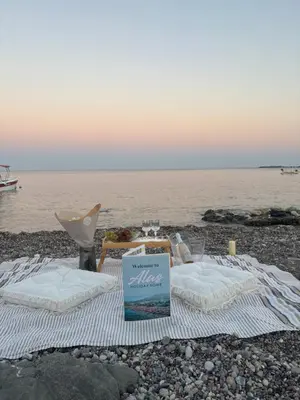 a picnic table on the beach with a view of the water at Álas Holiday Home in Archangelos