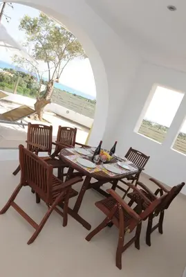 a dining room table and chairs with a view of the ocean at Gennadi Aegean Horizon Villas in Gennadi