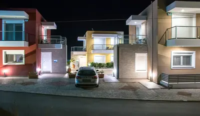 a car parked in a parking lot between two buildings at Gennadi Aegean Horizon Villas in Gennadi