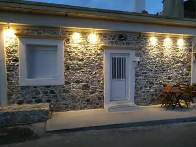 a stone house with lights on the side of it at Apollon Traditional House in Apóllona