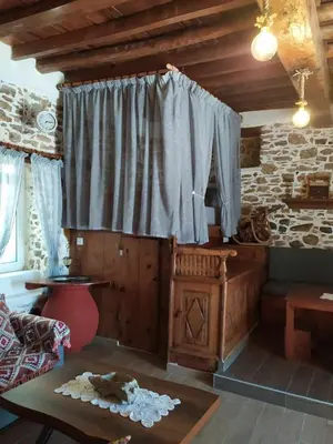 a living room with a large window and a table at Apollon Traditional House in Apóllona