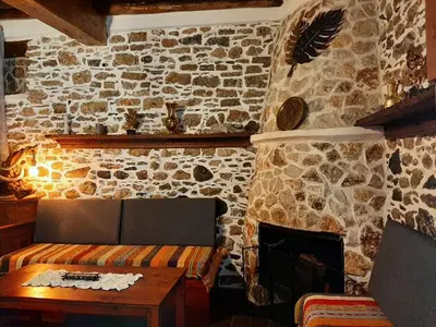 a stone room with a bed and a fireplace at Apollon Traditional House in Apóllona