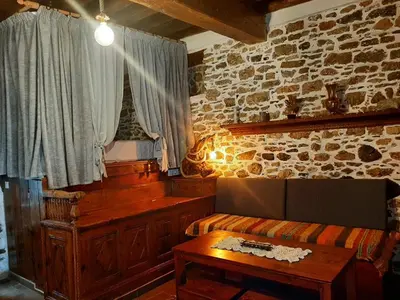 a room with a couch and a table and a window at Apollon Traditional House in Apóllona