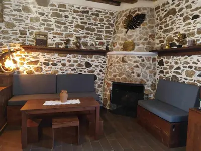 a living room with a couch and a table and a fireplace at Apollon Traditional House in Apóllona