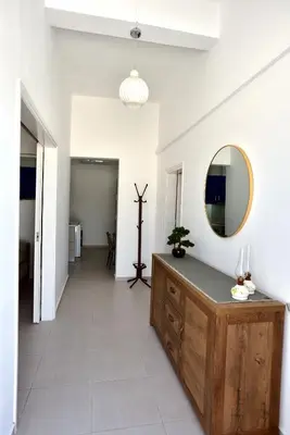 a hallway with a mirror and a wooden dresser at Athina's house in Archangelos