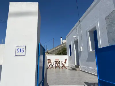 a patio with chairs and a table on a building at Athina's house in Archangelos