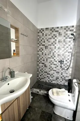 a bathroom with a sink and a toilet and a shower at Athina's house in Archangelos